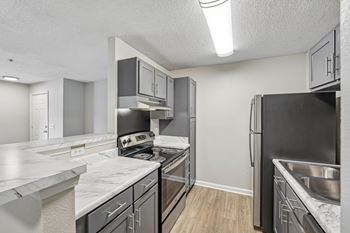 A kitchen with stainless steel appliances and marble countertops.